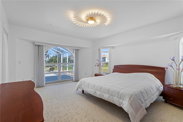 bedroom featuring carpet flooring, access to exterior, and a textured ceiling