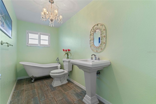 bathroom with hardwood / wood-style floors, toilet, a tub, and a chandelier