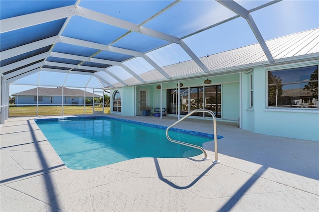 view of pool featuring a patio, glass enclosure, and ceiling fan