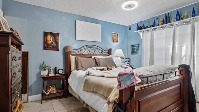 bedroom with light tile patterned floors and a textured ceiling