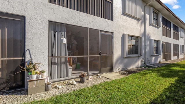 view of property exterior with a sunroom and a yard