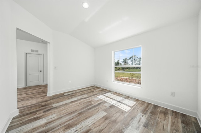 unfurnished room featuring hardwood / wood-style floors and vaulted ceiling