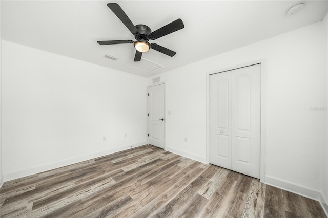 unfurnished bedroom featuring a closet, hardwood / wood-style flooring, and ceiling fan