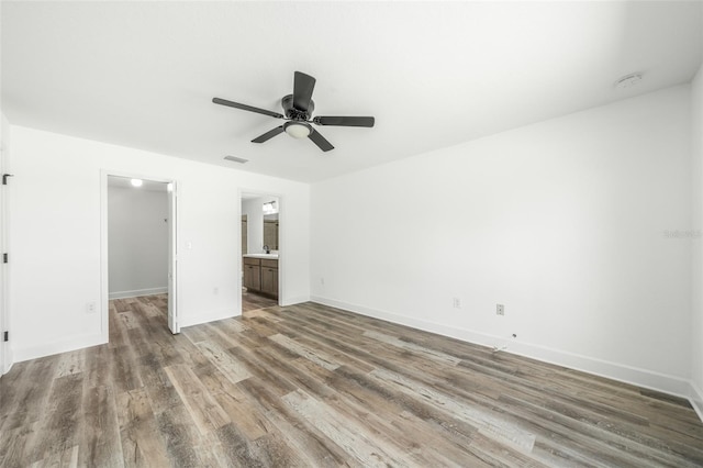 interior space featuring connected bathroom, a spacious closet, sink, ceiling fan, and hardwood / wood-style flooring