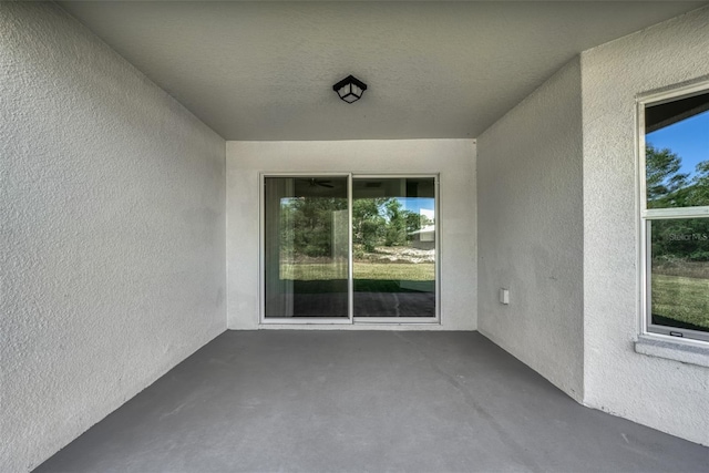 view of exterior entry with a patio area