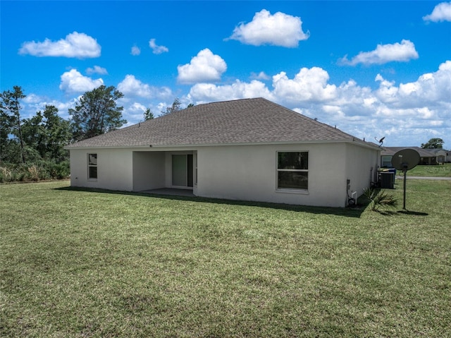 rear view of property featuring a lawn