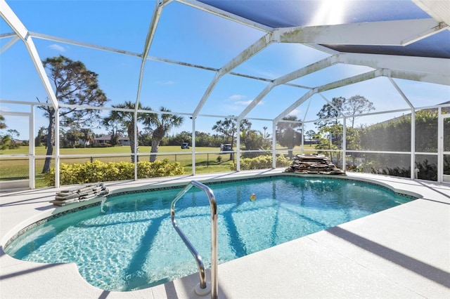 view of pool with glass enclosure and a patio area