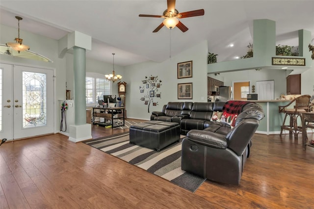 living room featuring french doors, ceiling fan with notable chandelier, dark hardwood / wood-style floors, and vaulted ceiling