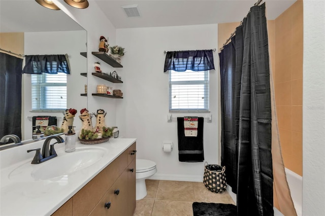 bathroom with tile patterned flooring, vanity, a healthy amount of sunlight, and toilet