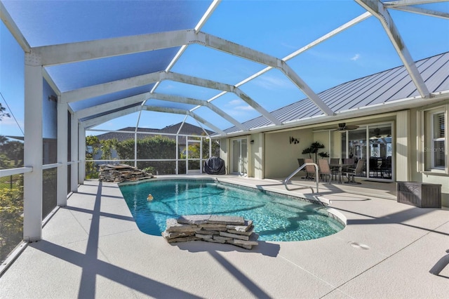 view of swimming pool with glass enclosure, ceiling fan, and a patio area