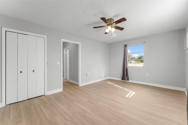 unfurnished bedroom featuring ceiling fan, light hardwood / wood-style floors, a textured ceiling, and a closet