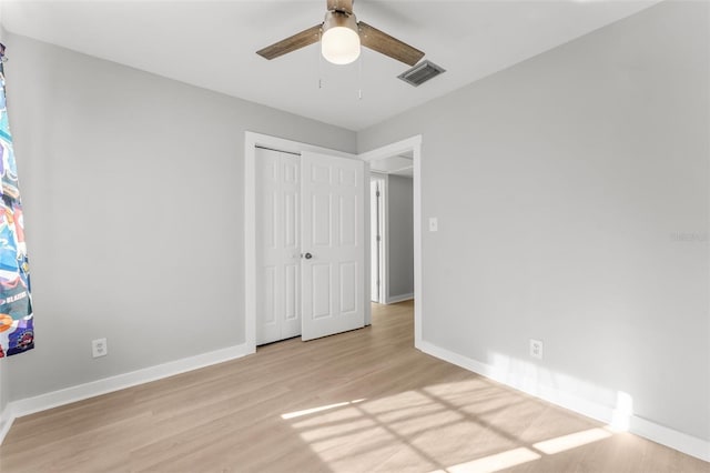 unfurnished bedroom featuring light wood-type flooring, a closet, and ceiling fan