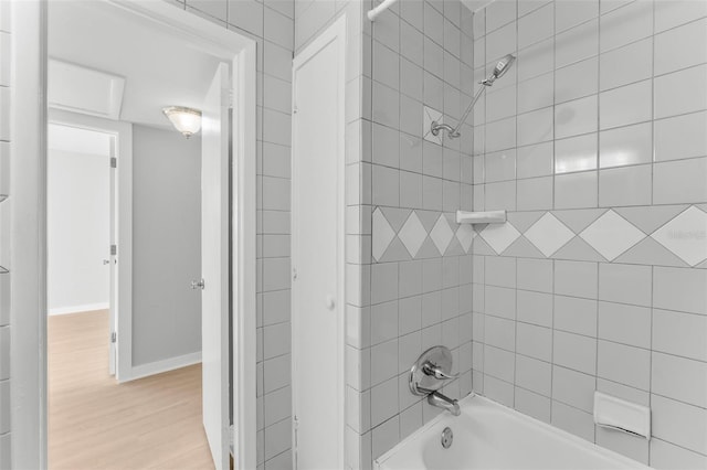 bathroom with hardwood / wood-style floors and tiled shower / bath combo