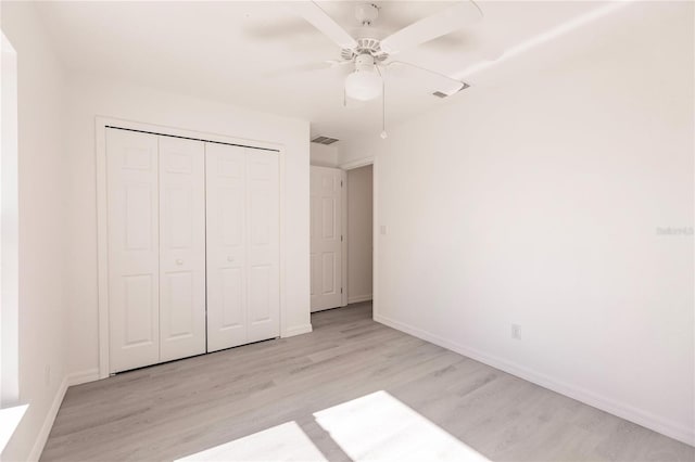 unfurnished bedroom with ceiling fan, a closet, and light hardwood / wood-style floors