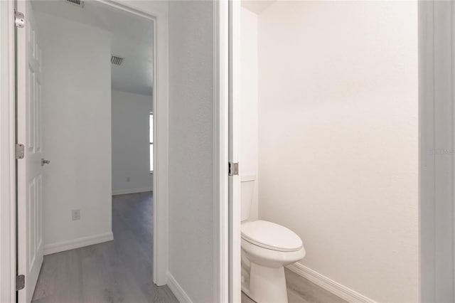 bathroom featuring wood-type flooring and toilet