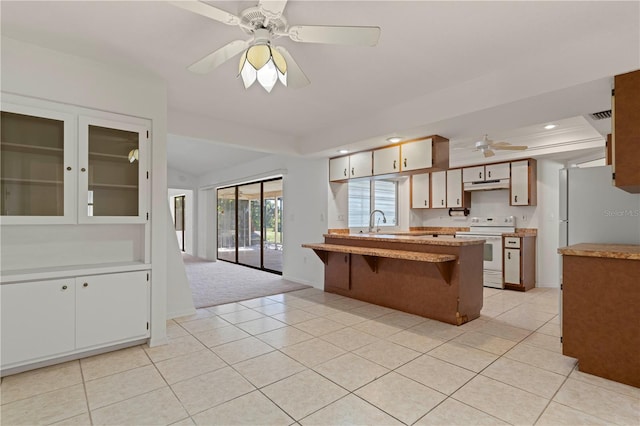 kitchen with white cabinetry, white appliances, and light tile patterned floors