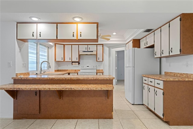 kitchen featuring white cabinets, white refrigerator, sink, ornamental molding, and range