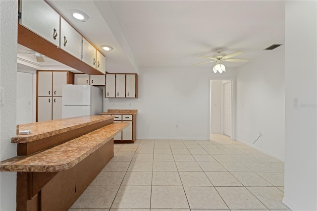 kitchen with ceiling fan, white fridge, and light tile patterned floors