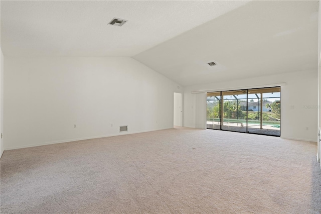 spare room with light colored carpet and lofted ceiling