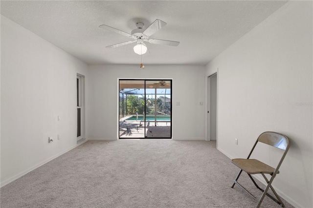 unfurnished room featuring a textured ceiling, ceiling fan, and light carpet