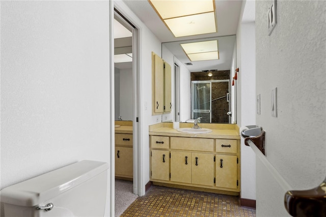 bathroom with tile patterned floors, vanity, toilet, and a shower with shower door