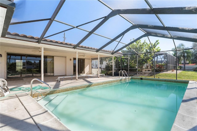 view of pool featuring glass enclosure, ceiling fan, and a patio area