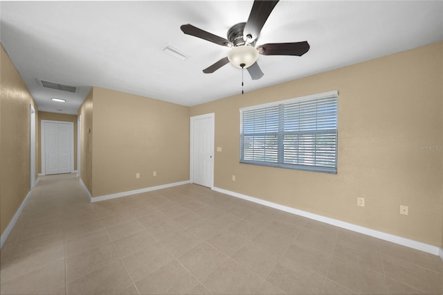 tiled spare room with ceiling fan