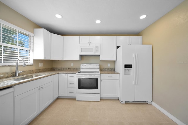 kitchen with white appliances, white cabinetry, and sink