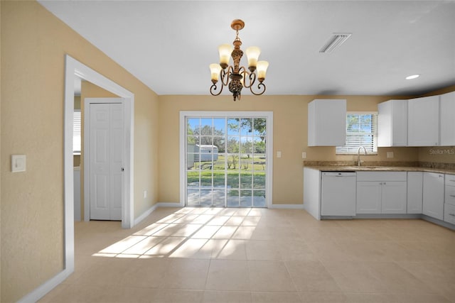 kitchen featuring a healthy amount of sunlight, dishwasher, white cabinets, and hanging light fixtures