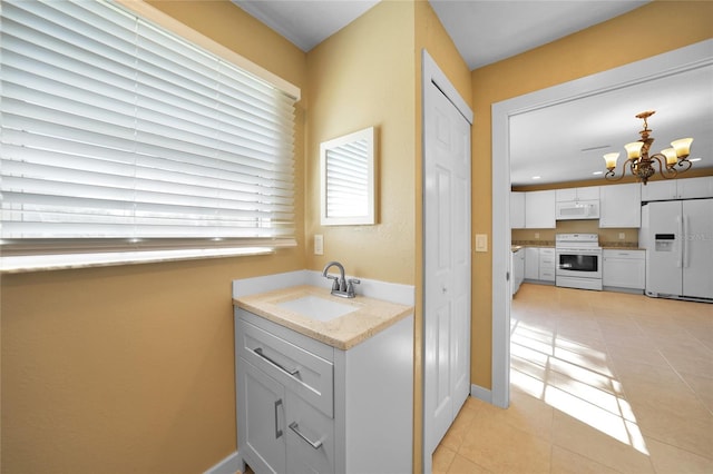 bathroom with tile patterned floors, sink, and a chandelier