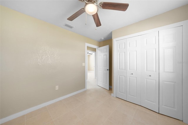 unfurnished bedroom with light tile patterned floors, a closet, and ceiling fan