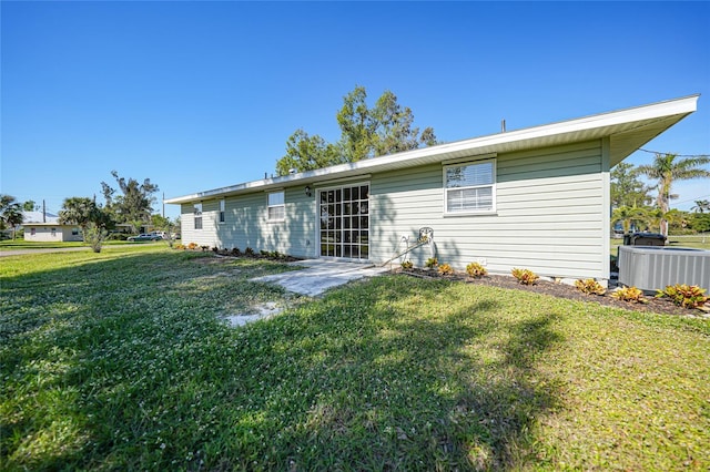 rear view of property with a yard and central AC unit