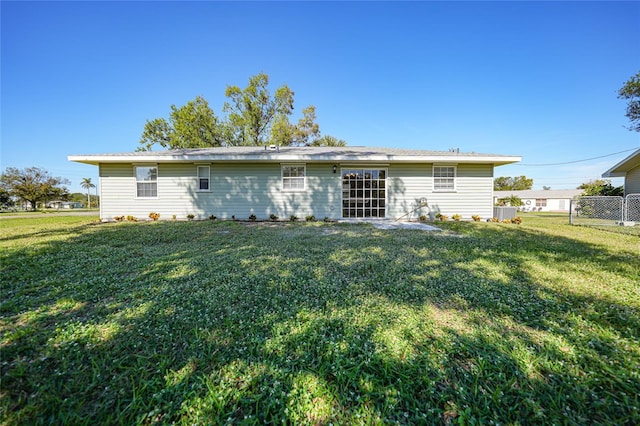 rear view of property featuring a lawn