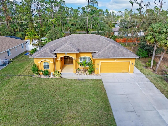 ranch-style house featuring central air condition unit, a front yard, and a garage