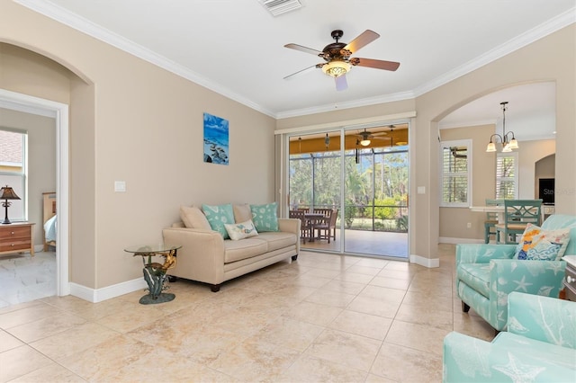 living room with ceiling fan with notable chandelier, crown molding, and a wealth of natural light