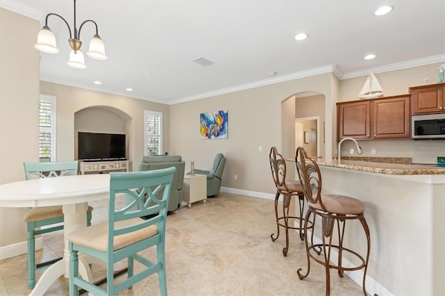 kitchen with crown molding, a wealth of natural light, and a chandelier