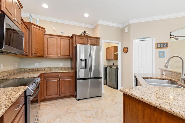 kitchen featuring light stone countertops, stainless steel appliances, crown molding, sink, and independent washer and dryer