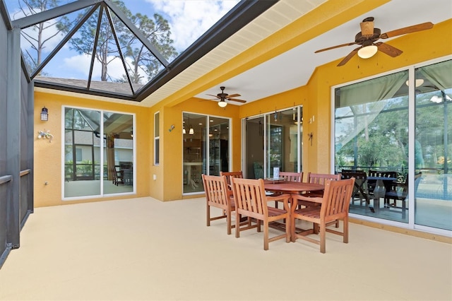 sunroom / solarium with ceiling fan, beamed ceiling, and a healthy amount of sunlight