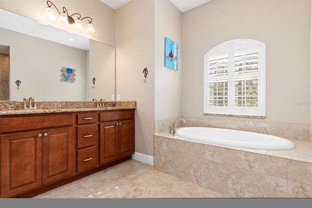 bathroom featuring tiled bath, tile patterned flooring, and vanity