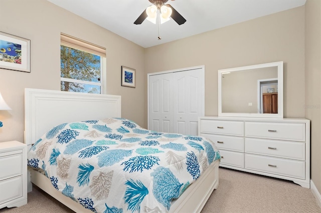 carpeted bedroom featuring ceiling fan and a closet