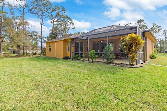 back of property with a lawn, glass enclosure, and a patio