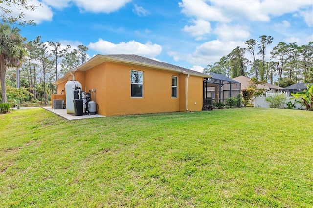 rear view of property featuring a yard, cooling unit, and a lanai