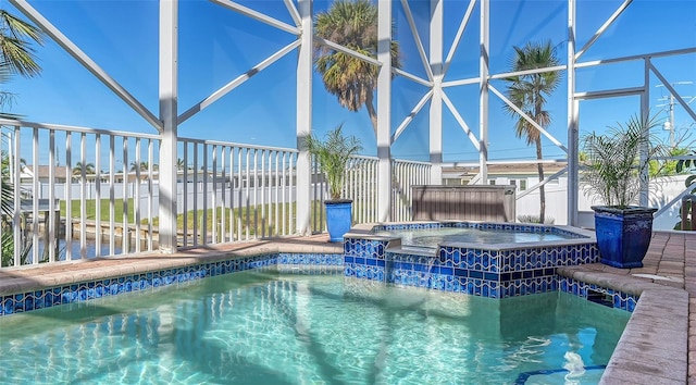 view of pool with glass enclosure and an in ground hot tub