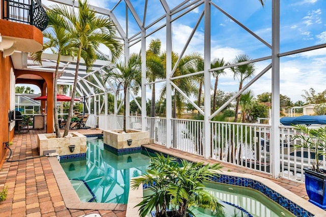 view of swimming pool with a lanai and a hot tub