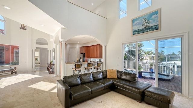 living room featuring decorative columns and a high ceiling