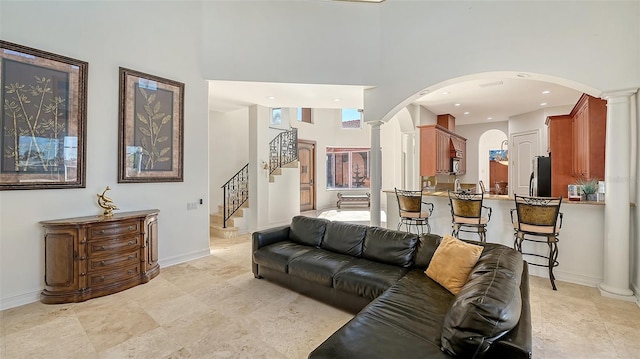 living room with a towering ceiling and ornate columns