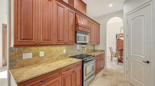 kitchen featuring decorative backsplash, light stone counters, light tile patterned floors, and appliances with stainless steel finishes