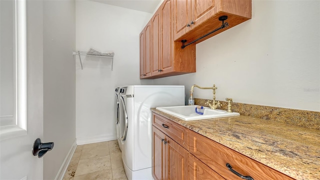 washroom with washing machine and clothes dryer, sink, light tile patterned floors, and cabinets