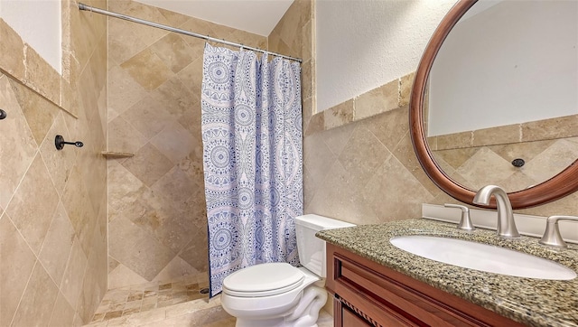 bathroom with a shower with shower curtain, vanity, toilet, and tile walls