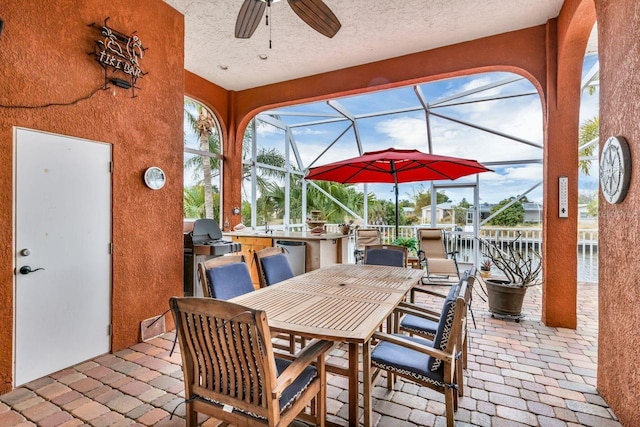 view of patio / terrace with ceiling fan and a lanai